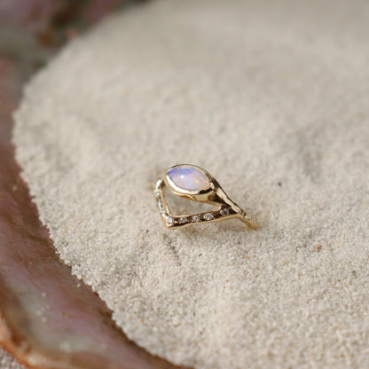 Horizontal marquise opal on a slender band with an organic diamond-set V accent, creating a stunning and unique ring design.