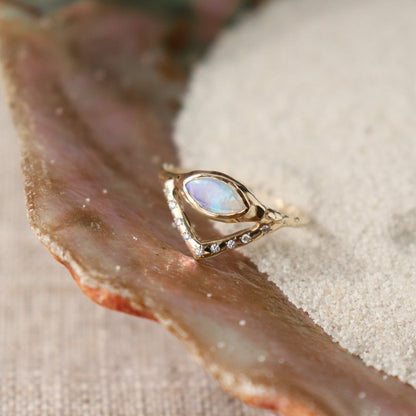 Horizontal marquise opal on a slender band with an organic diamond-set V accent, creating a stunning and unique ring design.