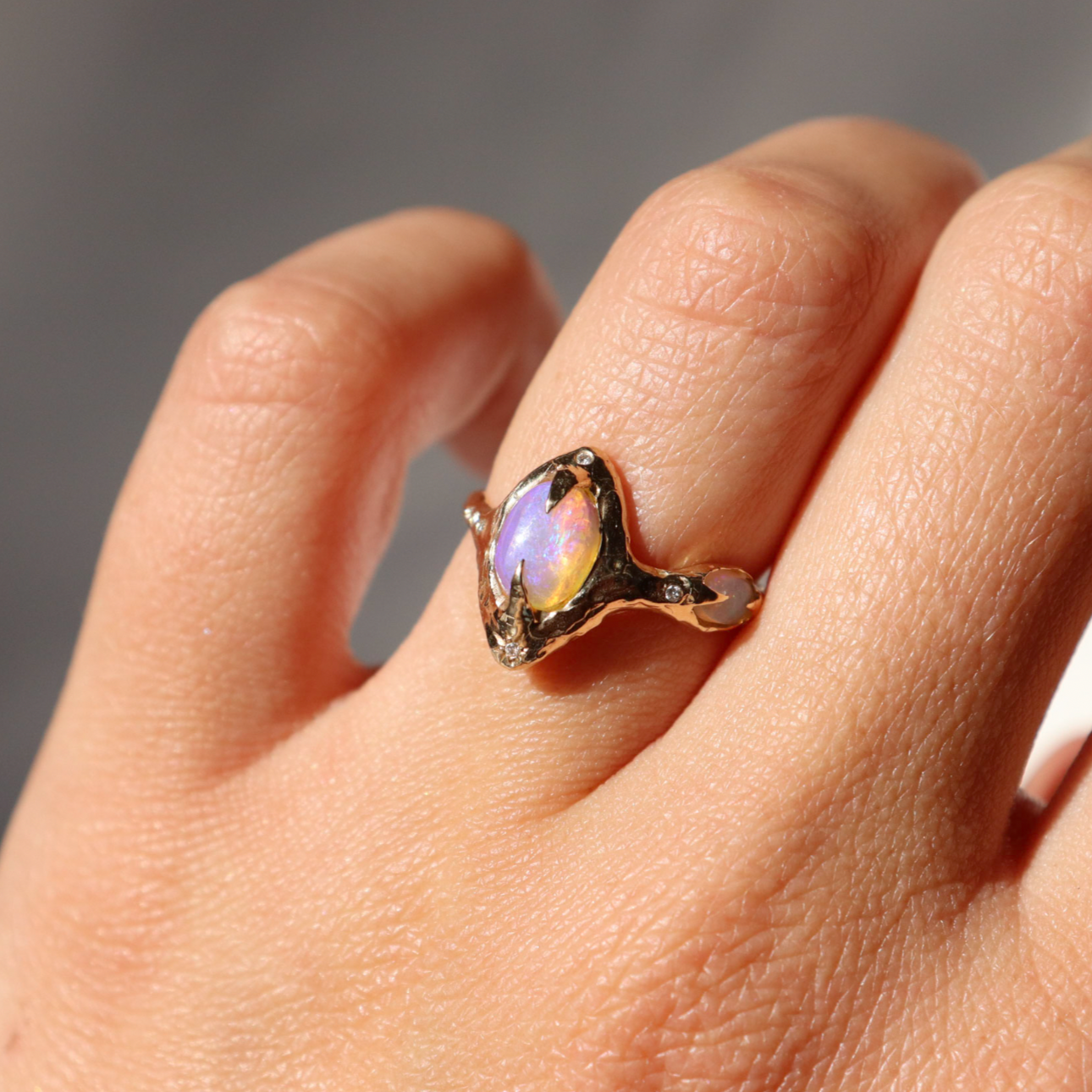gold pipe opal ring is worn on a ring finger