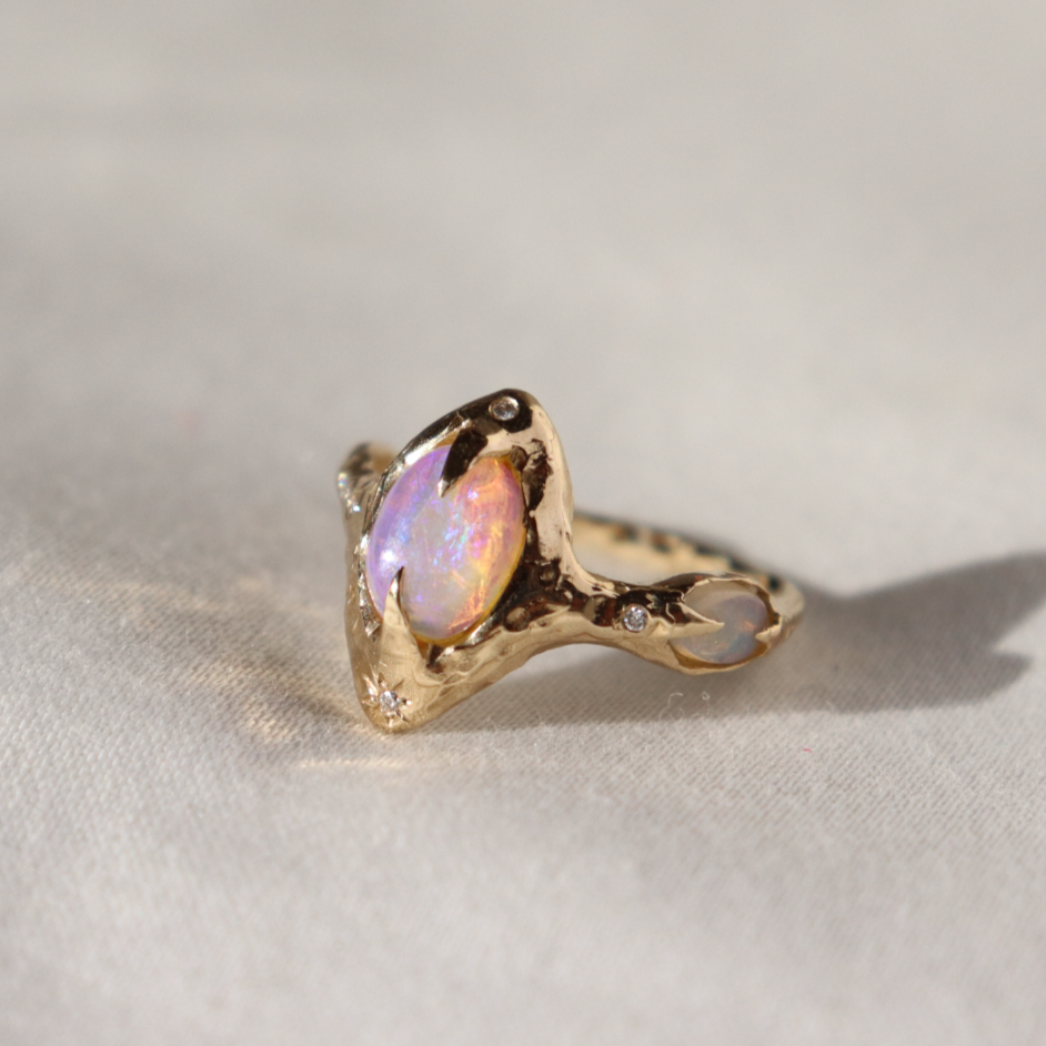 pipe opal ring with diamonds sits on a white surface