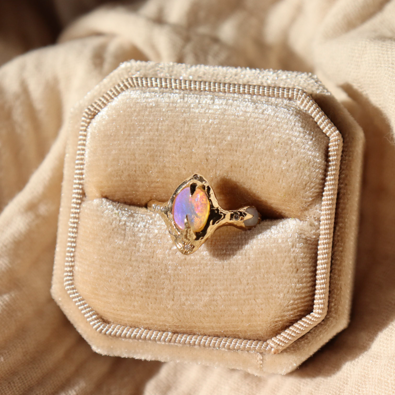 gold pipe opal ring sits inside a velvet ring box