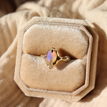 gold pipe opal ring sits inside a velvet ring box