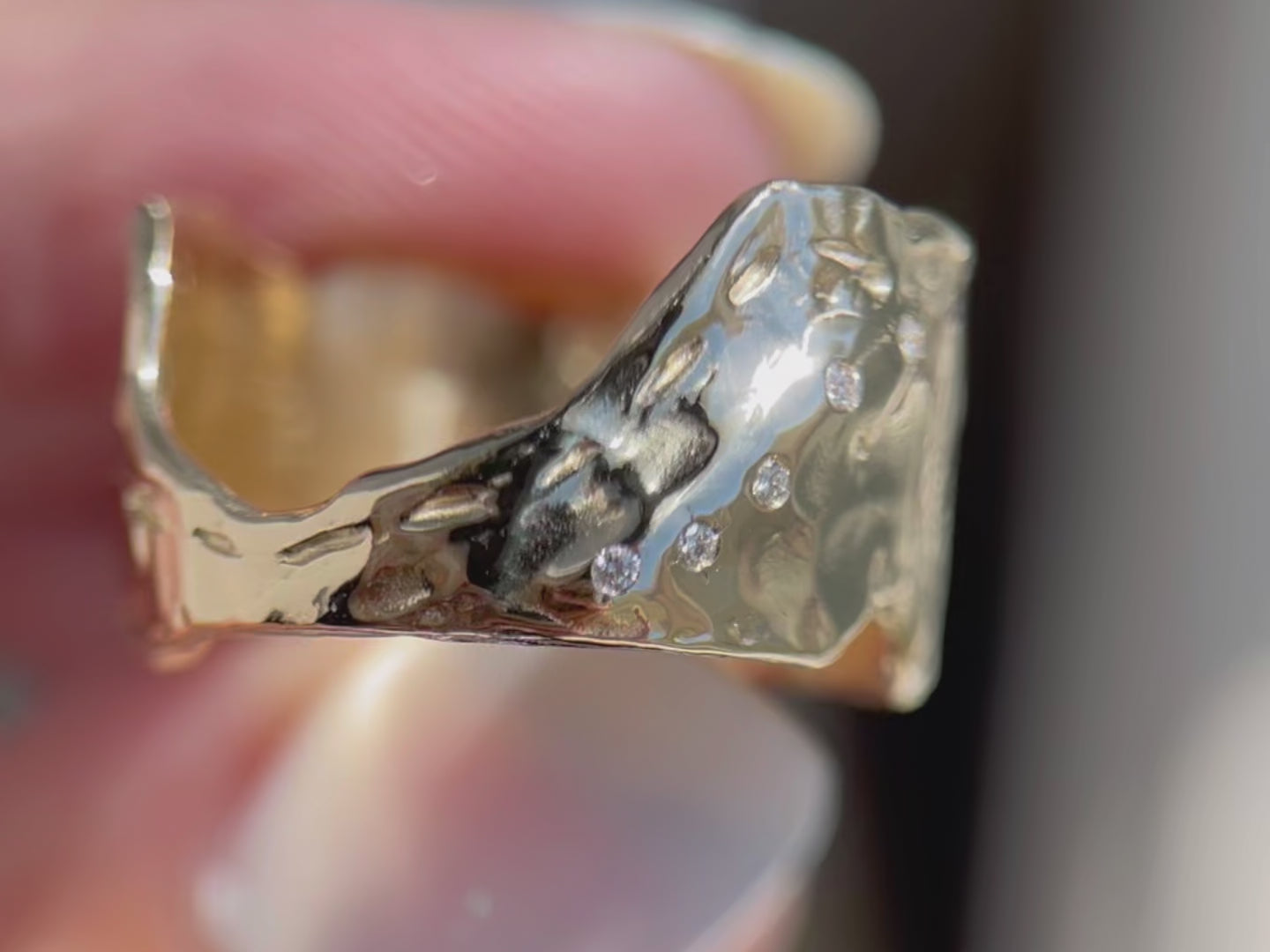 Close up video of a wide textured band that has a etching of a map and diamonds along the side.