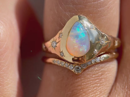 up close detail video of a gold opal ring with diamond star set accents and a pave diamond band