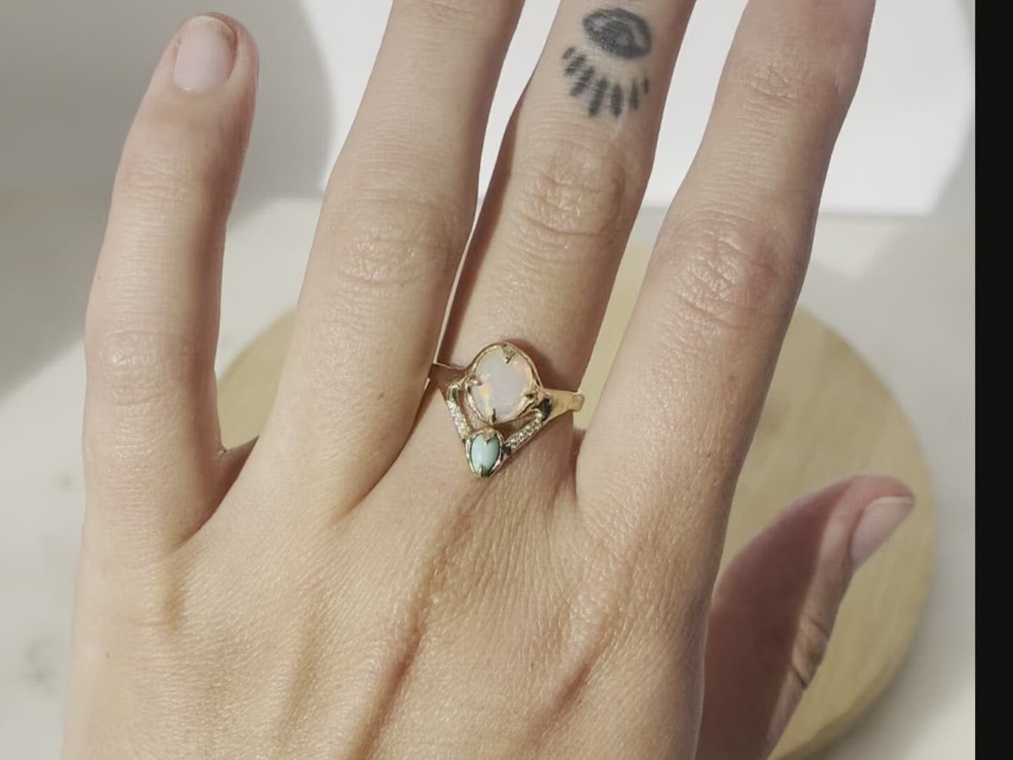 video of opal, turquoise, and diamond ring on a models hand