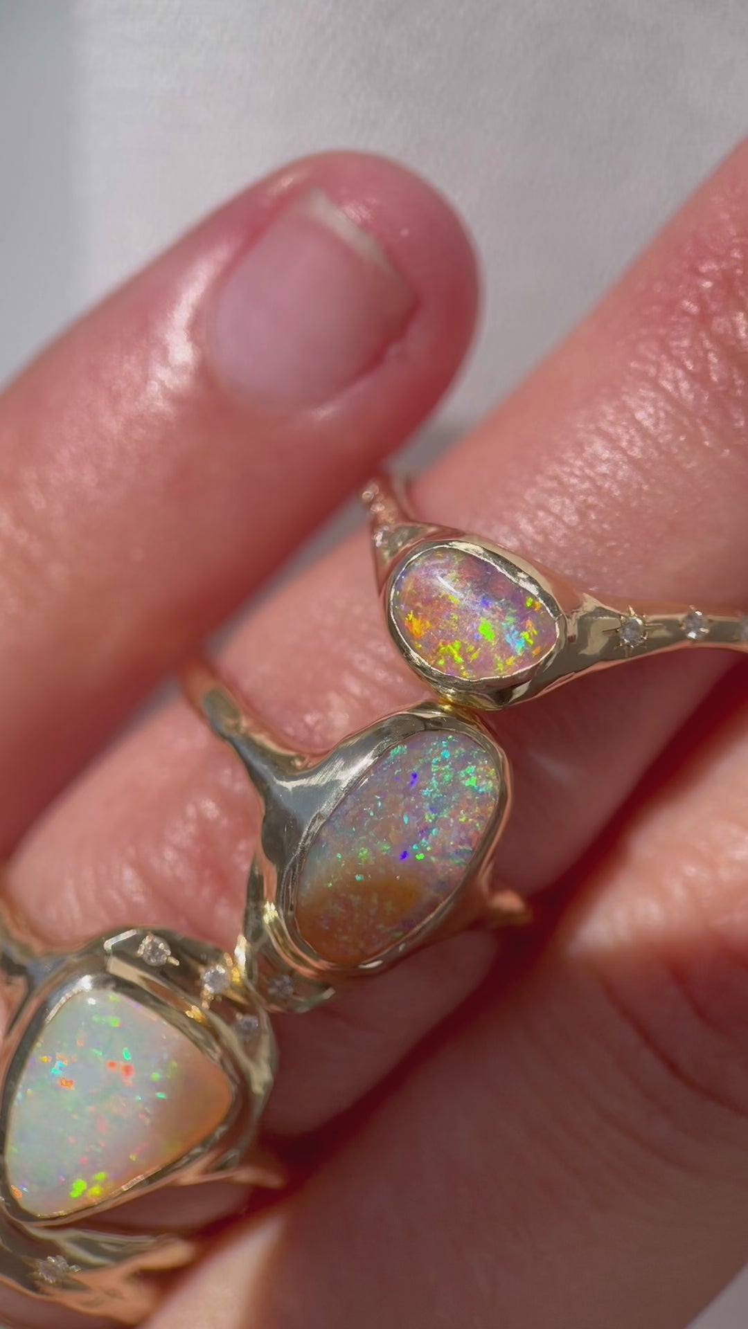 A close up video of unique opal rings worn to show color and size.