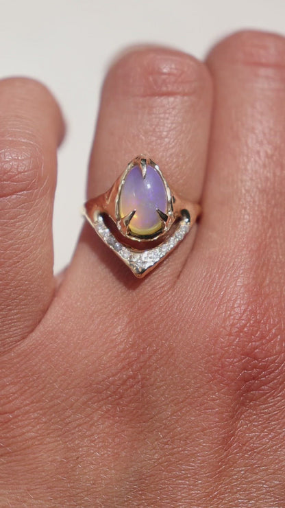 close up video of a pipe opal ring set in gold with pave diamonds