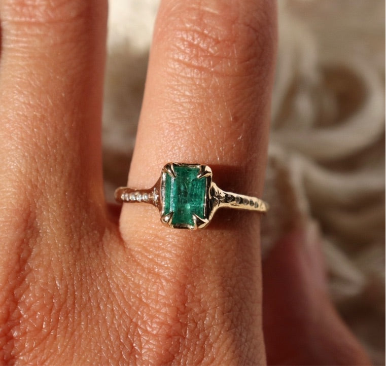 emerald cut emerald ring set in 14k gold with diamond accents